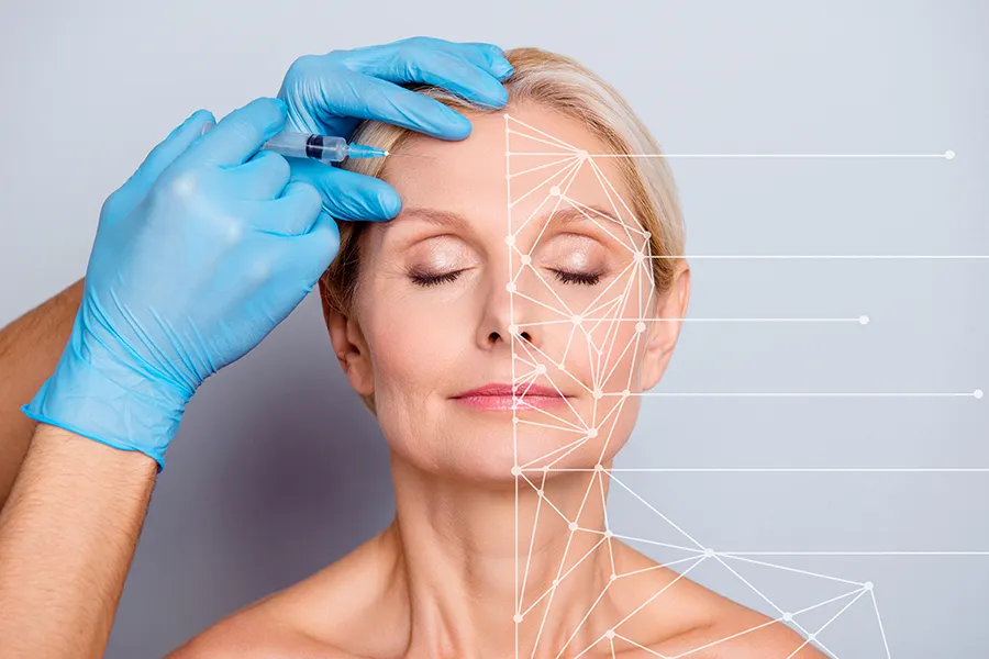 Aesthetic-Injectables-Clinic A mature blonde woman gets a facial injection. Get injectable aesthetic treatments from Brandi Terra, NP at Oak & Stone Wellness in East San Diego.