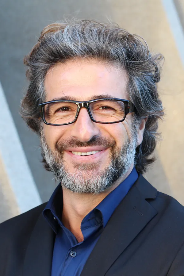 Andropause-and-Low-Testosterone-Treatment A man with glasses, salt and pepper hair and a beard smiling because he received treatment for andropause and low testosterone from Brandi Terra, NP at Oak & Stone Wellness in East San Diego.