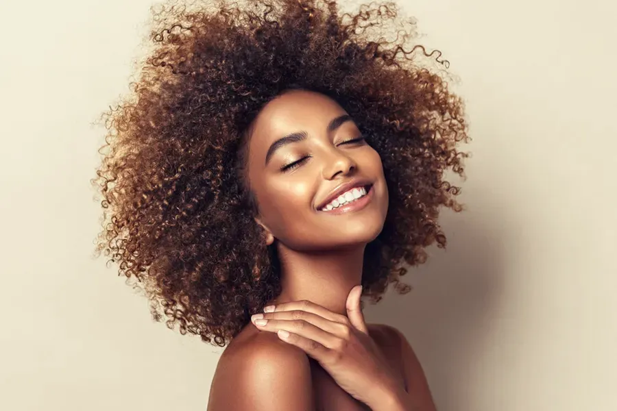Chemical-Peel-Doctor A black woman touches her beautiful smooth skin happily after receiving chemical peel treatments from Brandi Terra, NP at Oak & Stone Wellness in East San Diego.