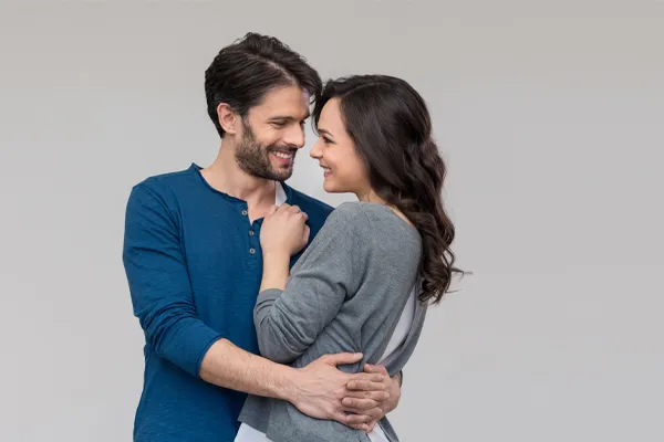 Erectile-Dysfunction-Doctor A man in a blue shirt embracing a woman in a gray shirt smiles due to his successful erectile dysfunction care from Brandi Terra, NP at Oak & Stone Wellness in East San Diego.