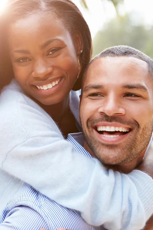 Erectile-Dysfunction-Treatment A woman riding on a man's back, both smiling due to help with erectile dysfunction from Brandi Terra, NP at Oak & Stone Wellness in East San Diego.