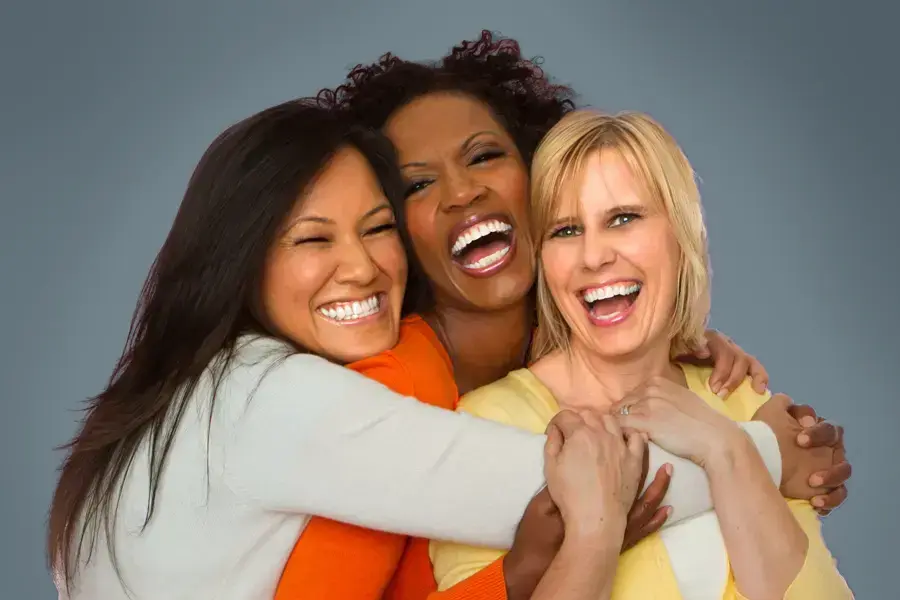 Insulin-Resistance-Clinic An asian, black, and white woman of middle age hug and laugh. Get insulin resistance treatment from Brandi Terra, NP at Oak & Stone Wellness in East San Diego.