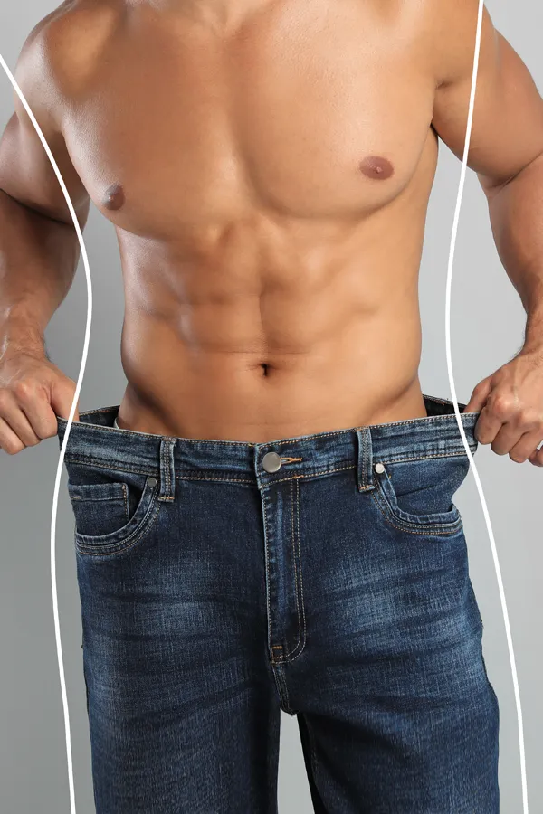 Semaglutide-Weight-Loss-Treatment A strong shirtless man in jeans holds the waistlines of his too-big jeans to show the success of semaglutide weight loss from Brandi Terra, NP at Oak & Stone Wellness in East San Diego.