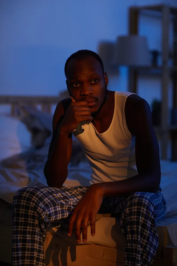 Sleep-Disorders-Treatment A man sits on the edge of his bed concerned that he can't sleep. Get treatment for sleep disorders from Brandi Terra, NP at Oak & Stone Wellness in East San Diego.