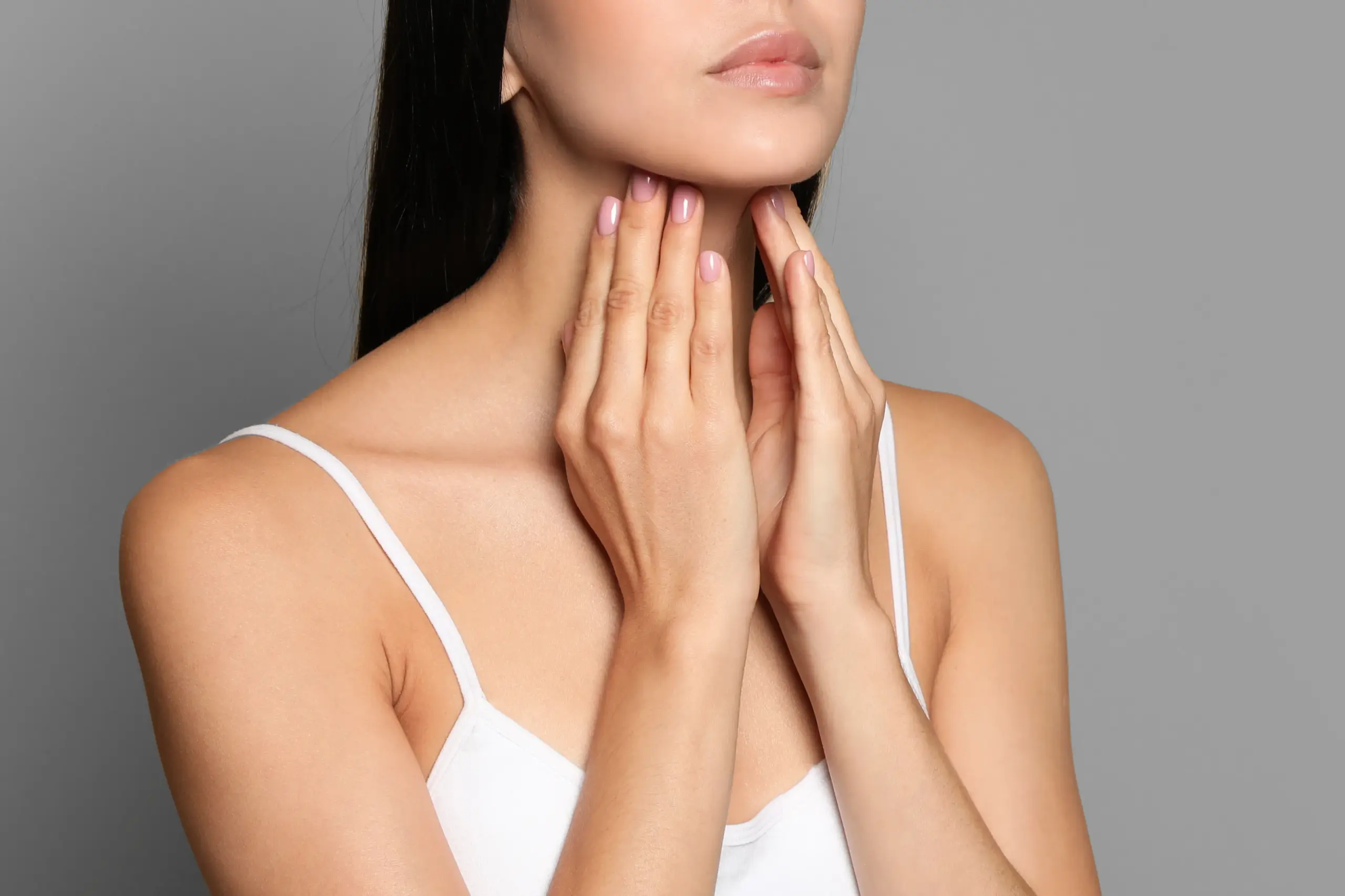Thyroid-Doctor A woman in a white tank top touches her neck looking for signs of thyroid disorder. Get help for thyroid disorders from Brandi Terra, NP at Oak & Stone Wellness in East San Diego.