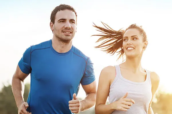 Weight-Loss-Resistance-Doctor A couple happily jogging in the sunlight after receiving effective weight loss resistance care from Brandi Terra, NP at Oak & Stone Wellness in East San Diego.